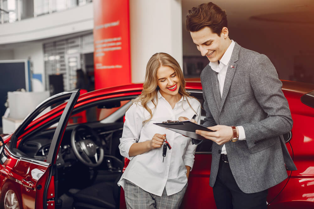 Woman buying the car. Lady in a car salon. 