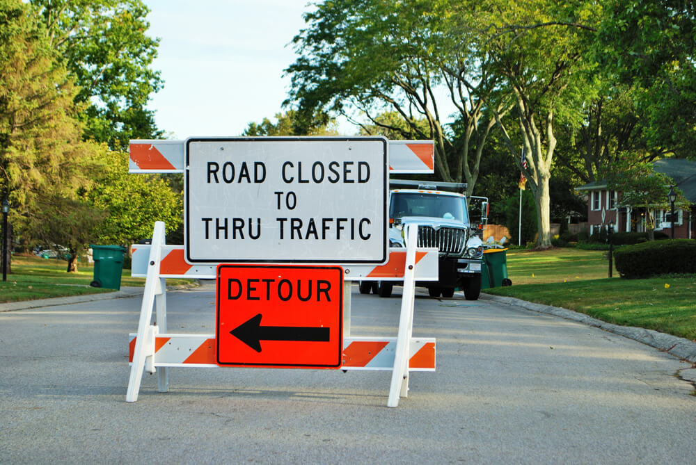 road closed to thru traffic detour construction sign in a residential neighborhood