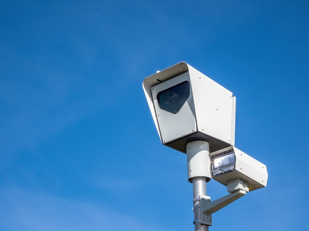 photo of a speed camera against a blue sky