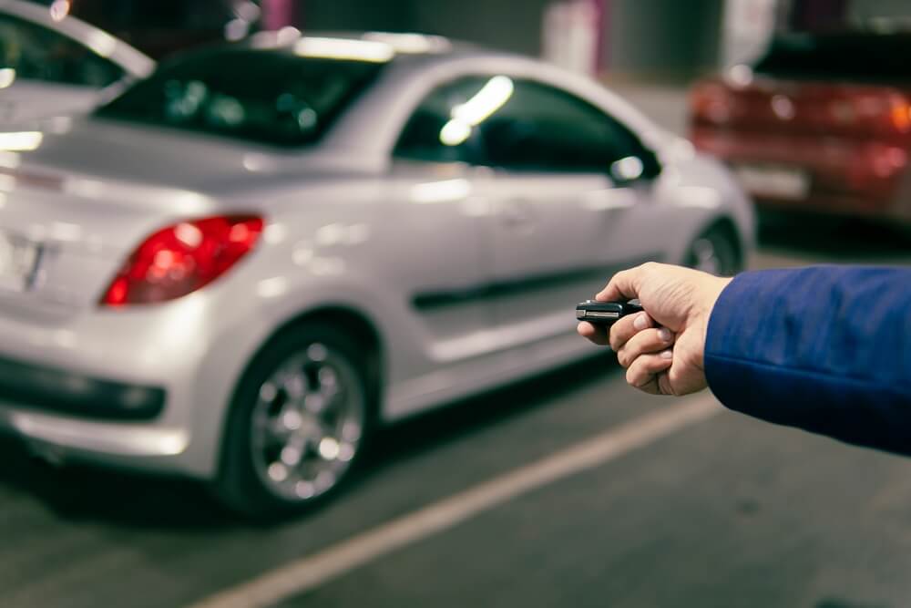 Hand holding a car alarm key with anti-theft