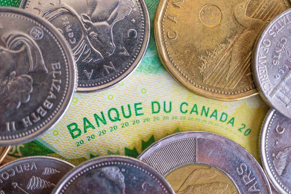 Canadian dollar coins on a Canadian bank note