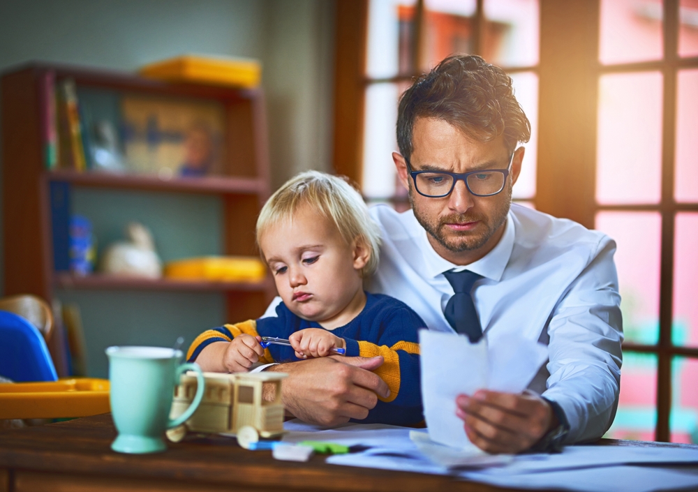 Man with kid, paperwork looking anxious in family home as a single parent