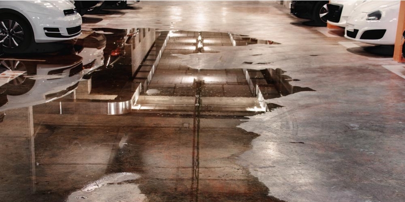 Water covers the floor of a parking garage