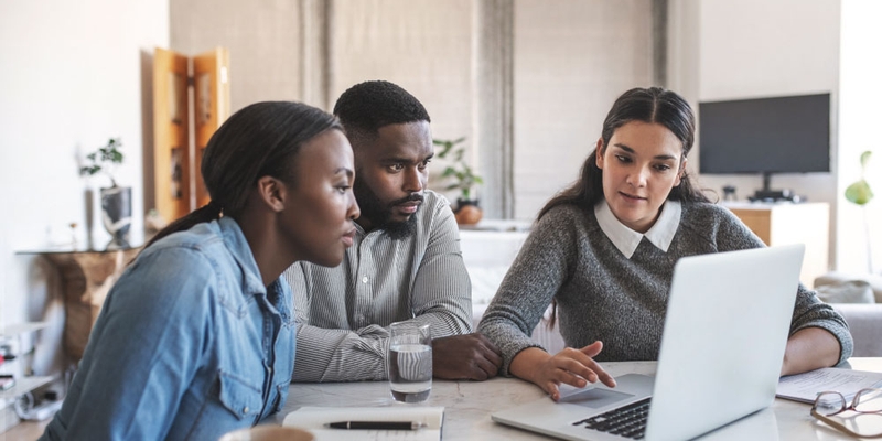 couple sitting with a financial advisor explaining financial products