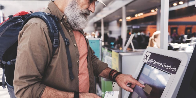 mature man checking in for a flight at the airport