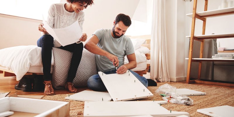 A couple builds ikea furniture together in their new home
