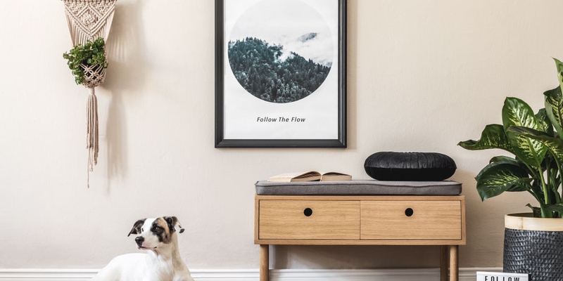 A cute terrier lays on the floor of a modern home