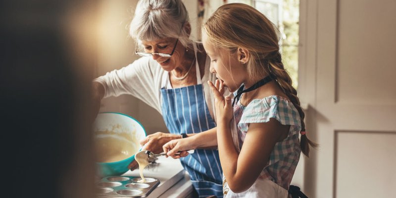 A grandma and her granddaughter bake in the kitchen