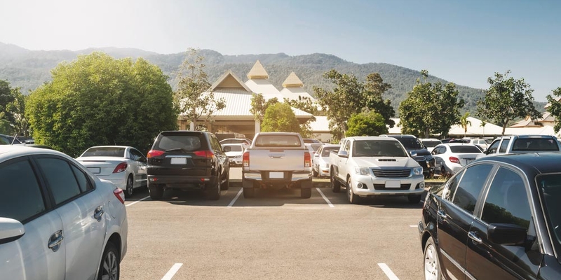 An empty parking spot in a crowded parking lot
