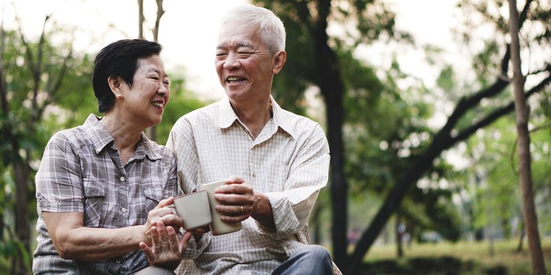Two seniors sit side by side enjoying the outdoors