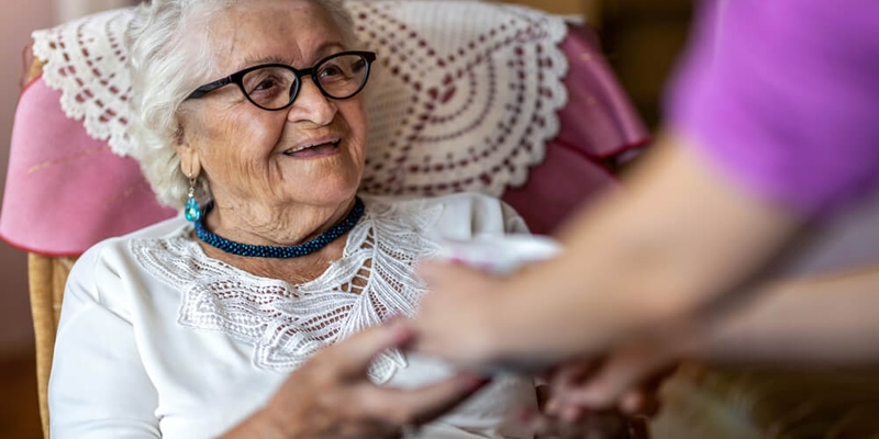 elderly woman being helped by a caregiver_aging in place.jpg