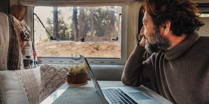 man on a computer working from woods_how to insure unconventional home_1.jpg