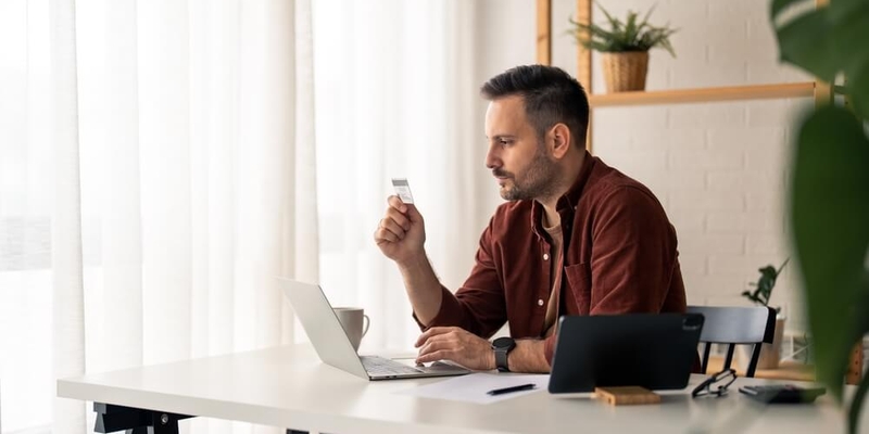 pensive looking freelancer staring intensely at his credit card_Should you accept that pre-approved credit limit (1).jpg