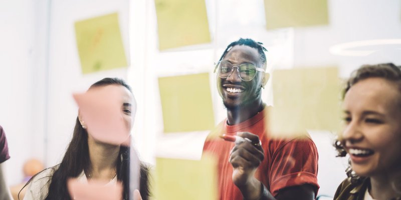 Young coworkers collaborate together with post-it notes at coworking space