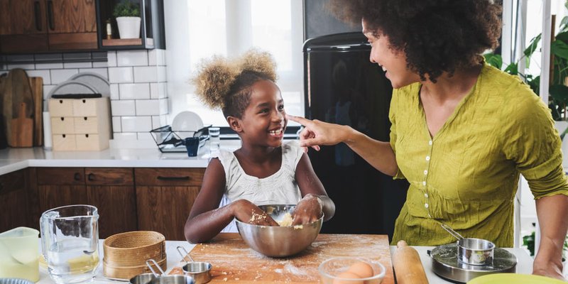 Mom and daughter baking together at kitchen island