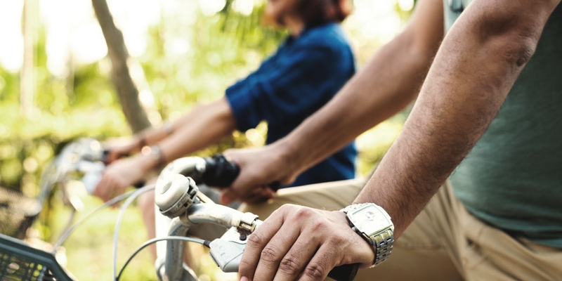 A close-up of someone with their hands on the handlebars of a bike