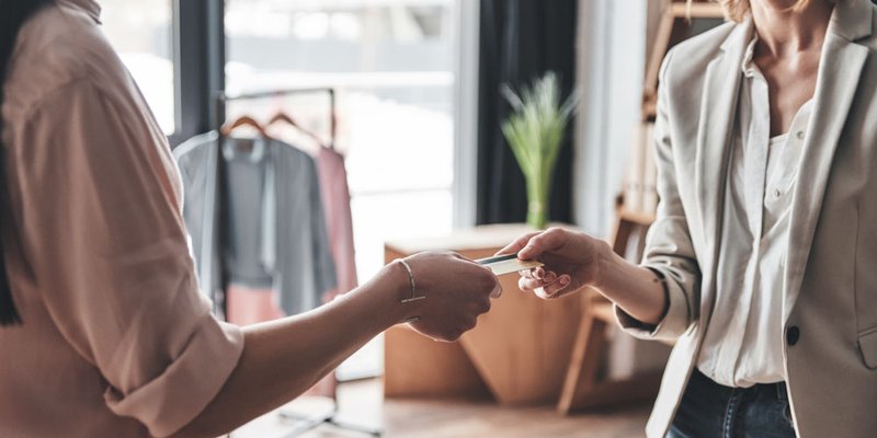A woman hands the customer her credit card back