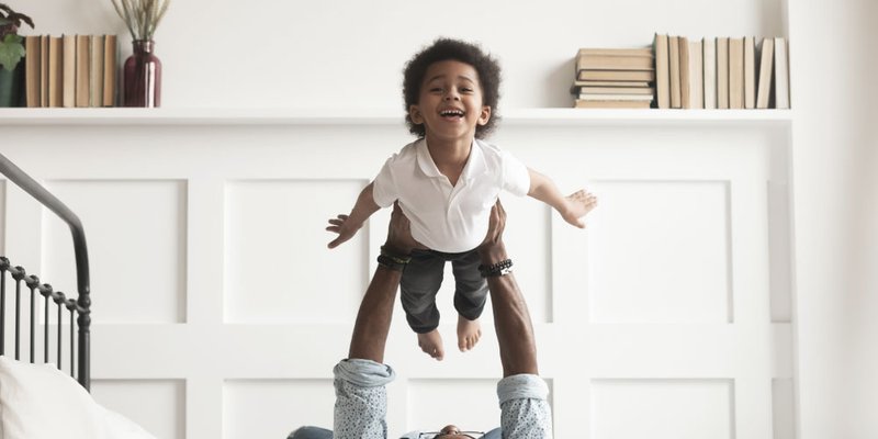 A father holds his son up in the air