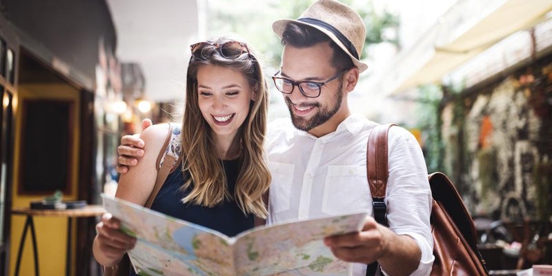 A young couple reads a map