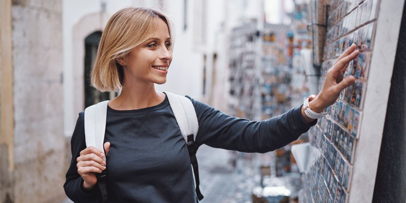 A woman touches the magnet souvenirs she is considering buying