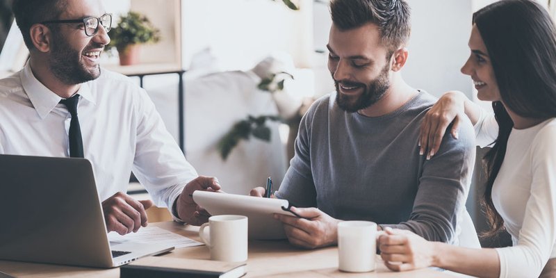 A man and his partner sign mortgage documents