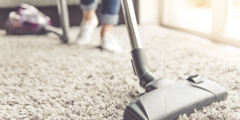 A close-up view of someone vacuuming a carpet