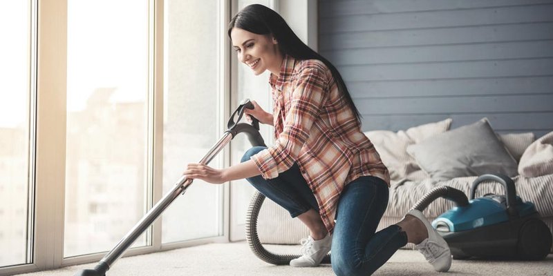 A woman vacuuming her carpet