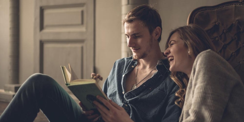 A young couple reading a book together