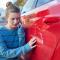 Young Worried Teenage Female Driver With Damaged Car After Accident Calling Insurance Company On Mobile Phone