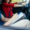 a woman in a red shirt taking an in-car driving lesson with instructor