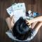 a girl sitting on the floor surrounded by bills and credit cards in a pile around her