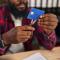 african american man in a red plaid shirt cutting up a blue credit card