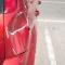the dented back bumper of a red car with the at-fault driver gone