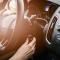 woman with red painted nails turning the ignition on in her car