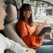 Happy young woman taking notes in notebook while sitting in car