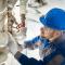 Male worker inspecting water valve for leaks in basement.jpg
