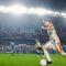 Soccer match Caucasian male player forward dribbles in stadium as fans cheer