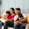 Family sitting on sofa and using tablet to browse home listings