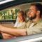 Father driving a car and traveling with his wife and daughters on a weekend trip away from the city