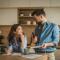 Couple facing financial challenges, calculating expenses, and planning their budget together on the kitchen counter, symbolizing stress and careful money management at home