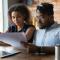 Millenial Black Couple Planning Family Budget in Home on Laptop
