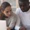 A man and woman calculate their finances on a laptop