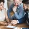A young couple speak with a broker and look at paperwork