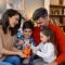 Happy family cheerful mother and father with kids smiling and putting coins into piggy bank while sitting on sofa at home (1).jpg