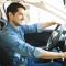 A young man uses the infotainment system in his car