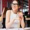 Portrait of smiling pretty young business woman in glasses sitting on workplace.jpg