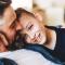 A son snuggles into his dad on the couch at home