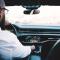 A man reaches for the volume dial while driving his car
