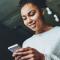 A young woman sends a message on her phone