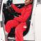 A woman gets out of her vehicle in the winter wearing a sweatsuit